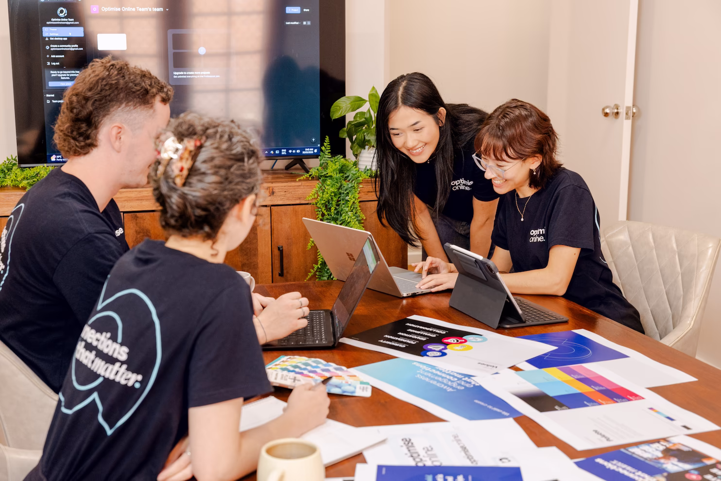 Optimise Online team collaborating on graphic design layouts and colour swatches
