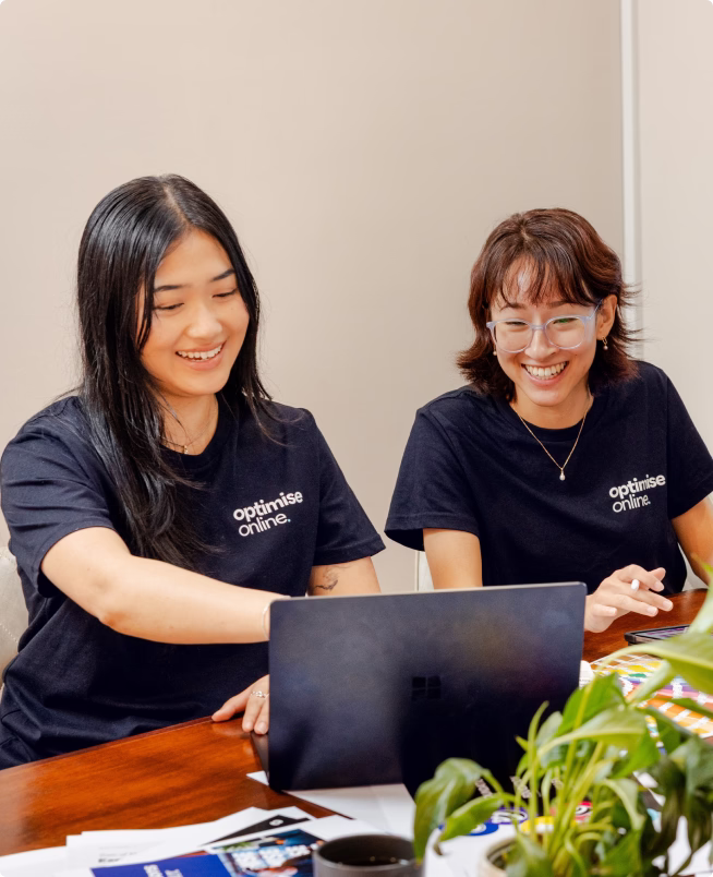 Optimise Online team members reviewing design work on a laptop